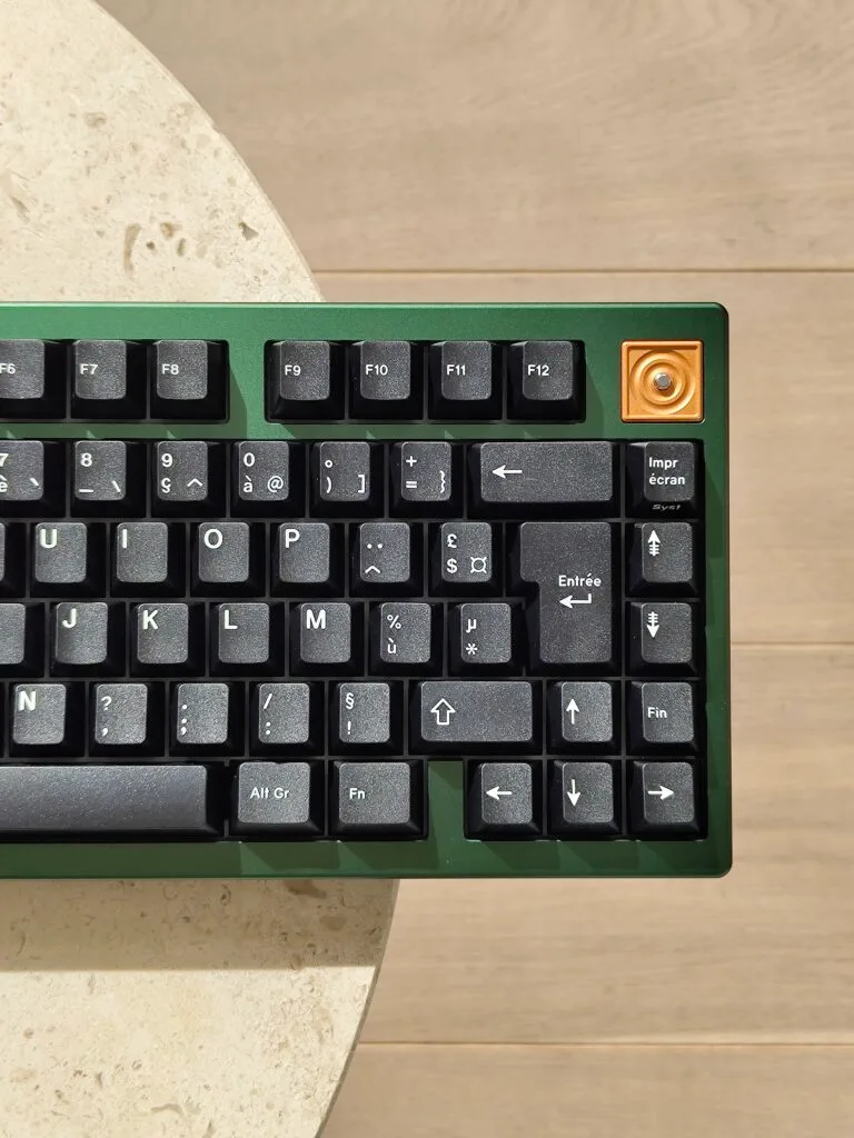 green and black mechanical keyboard with a copper accent