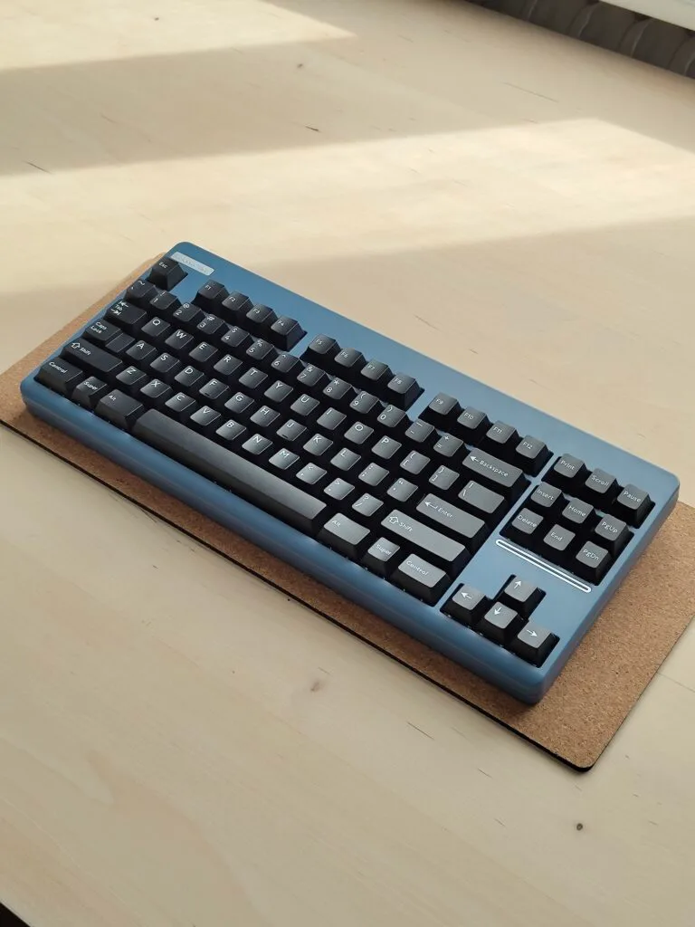 blue and black mechanical keyboard on a cork deskmat